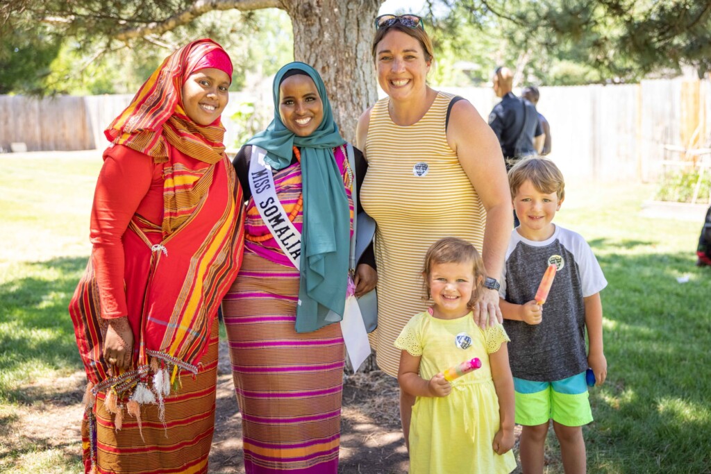 Miss Somalia poses with two women and two children at a Welcoming Week event.