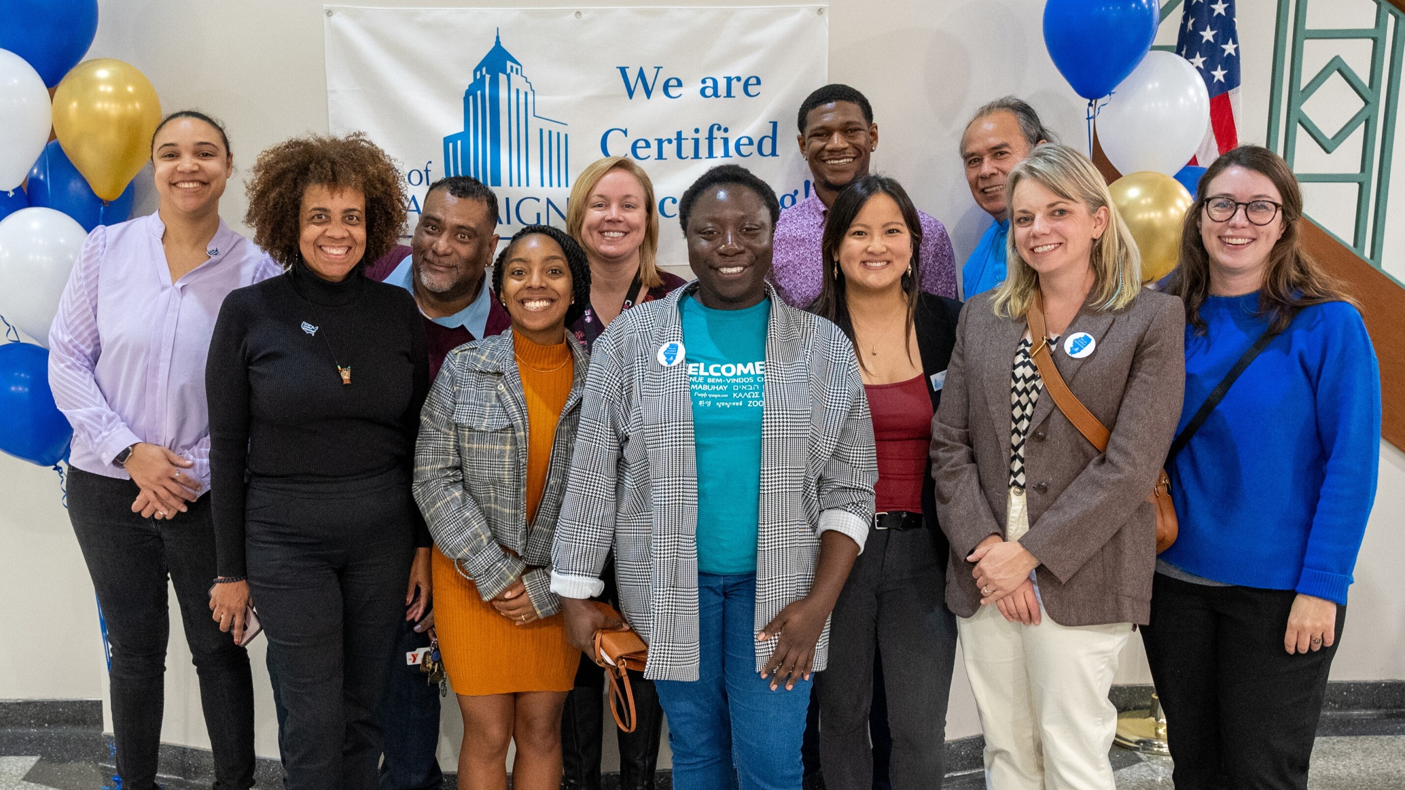 Group photo of partners in Champaign celebrating the announcement of their Certified Welcoming designation.